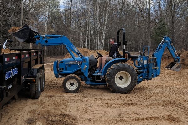 LS Tractor with FEL & Backhoe Loading Sand